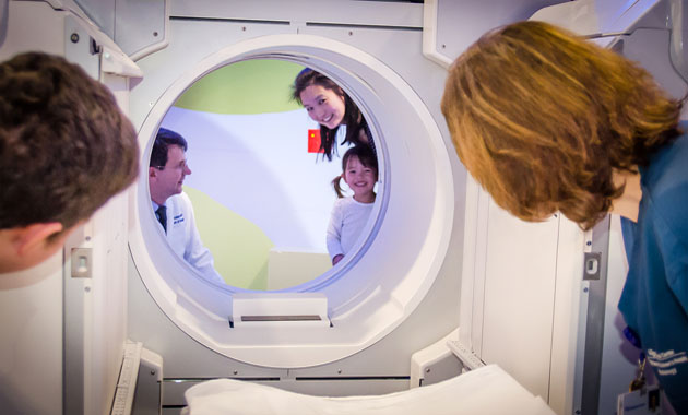 Young patient getting familiar with a SPECT-CT scanner