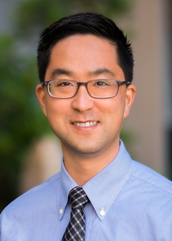Headshot of Jonathan Liu, MD, MS - man wearing classes and a blue shirt with a tie