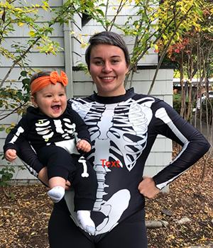 Tijana holding her daughter while they are wearing skeleton outfits 
