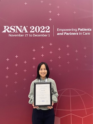 Dr. Xiao Wu poses with an award for the Trainee Research Prize.