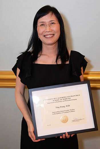 Ying Fung, MD, holding Outstanding Volunteer Clinical Physician Award